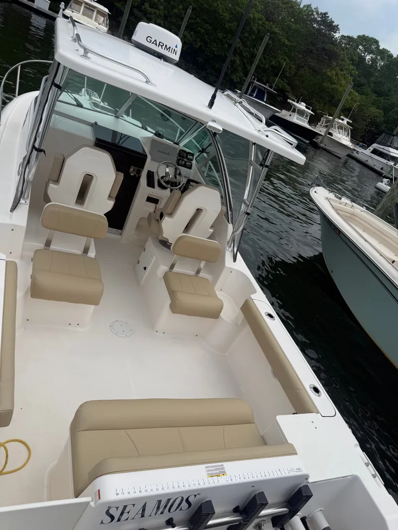Slide: The Image of A 2016 Pursuit OS 255 Offshore boat with beige seating and a Garmin system. - 6