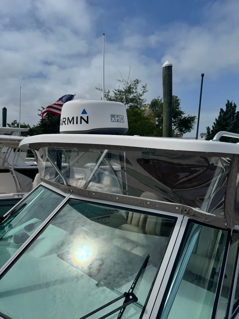 Slide: The Image of A 2016 Pursuit OS 255 Offshore with a Garmin radar on the roof, docked at a harbor. - 19