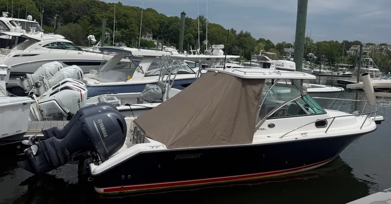 Slide: The Image of 2016 Pursuit OS 255 Offshore in a marina, featuring Yamaha outboard engines and a brown canopy. - 3