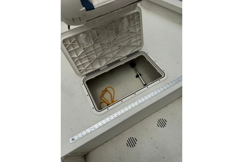 Slide: The Image of Open storage compartment on 2018 G3 Bay 18 DLX boat deck with measuring ruler. - 13