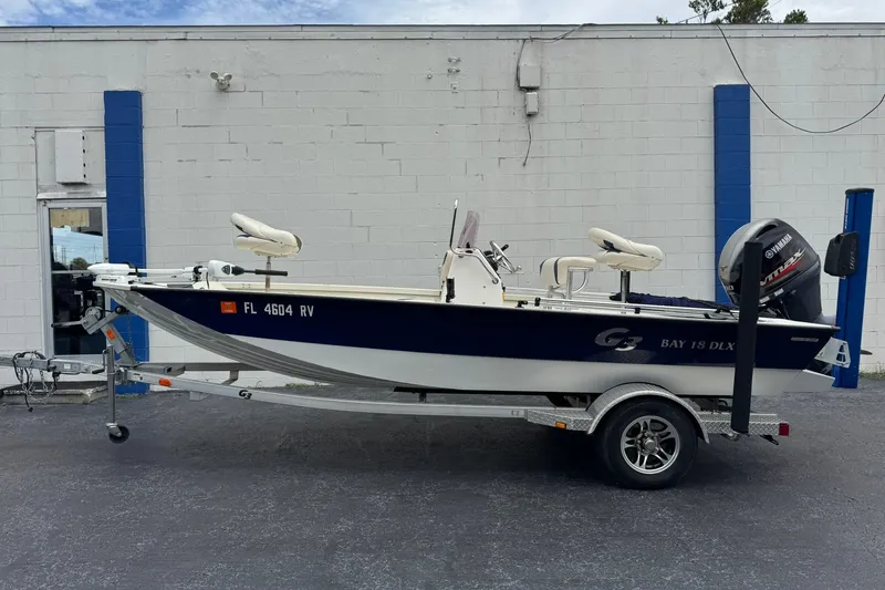Slide: The Image of 2018 G3 Bay 18 DLX boat on trailer, parked outside a building. - 1