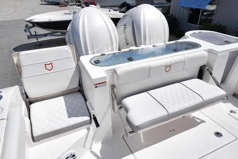 Slide: The Image of 2025 Sea Fox 328 Commander boat seating area with white upholstery and dual outboard engines. - 9