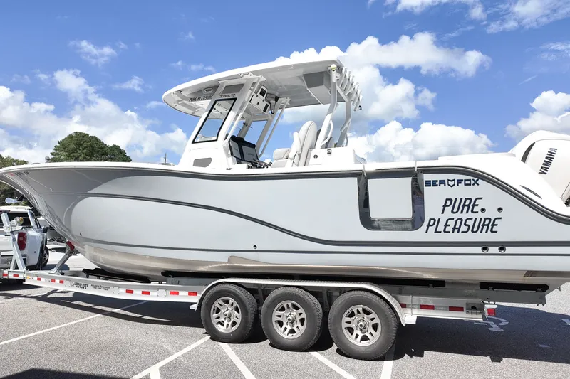 Slide: The Image of 2025 Sea Fox 328 Commander boat on trailer under blue sky. - 4