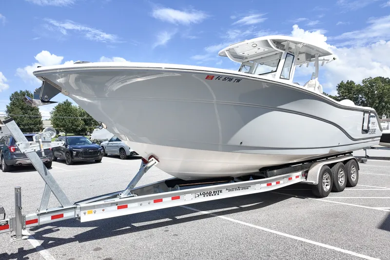 Slide: The Image of 2025 Sea Fox 328 Commander boat on trailer in parking lot under blue sky. - 5