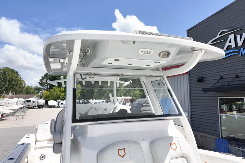 Slide: The Image of 2025 Sea Fox 328 Commander boat with sleek design at a marina under a clear sky. - 16