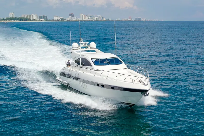 Slide: The Image of 2007 Mangusta 72 Motor Yacht cruising on open water near a city skyline. - 1
