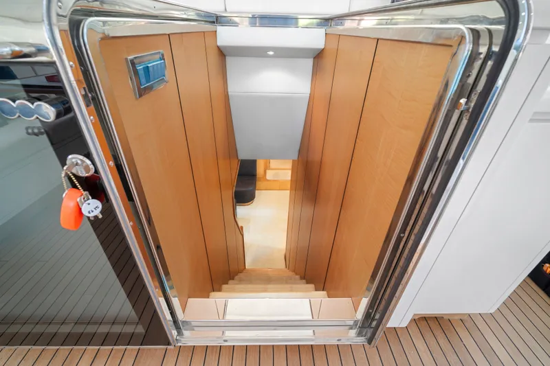 Slide: The Image of Staircase leading below deck on 2007 Mangusta 72 Motor Yacht, featuring wooden paneling. - 32