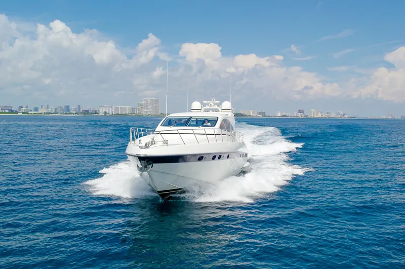 Slide: The Image of 2007 Mangusta 72 Motor Yacht cruising on open water with city skyline backdrop. - 2