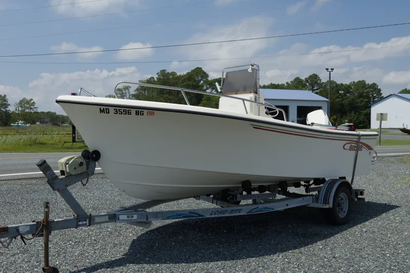 The Image of 1998 May-Craft 1900CC boat on trailer, parked outdoors under a clear sky. - 1