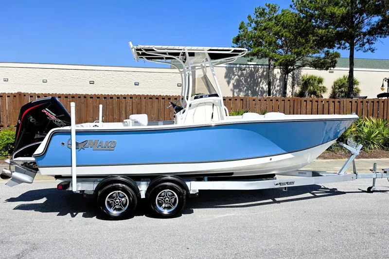 The Image of 2026 Mako 214 Center Console boat on trailer, blue hull, parked outdoors. - 0