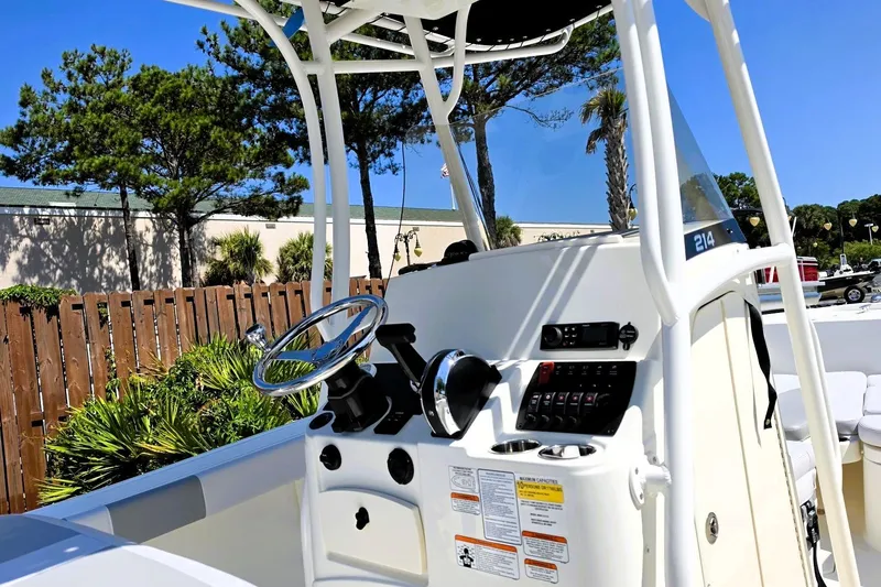 Slide: The Image of 2026 Mako 214 Center Console boat dashboard with steering wheel and controls. - 15