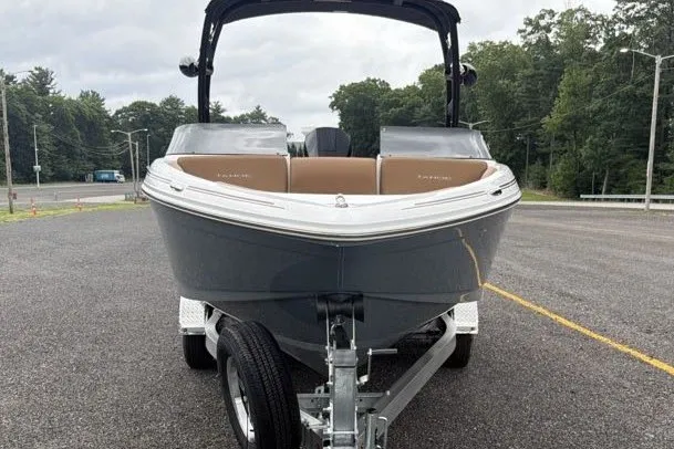 Slide: The Image of 2026 Tahoe 210 S boat on trailer, parked in outdoor lot with trees in background. - 6