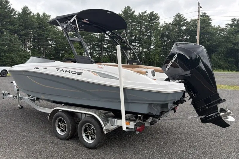 Slide: The Image of 2026 Tahoe 210 S boat on trailer with Mercury outboard motor, parked outdoors. - 4