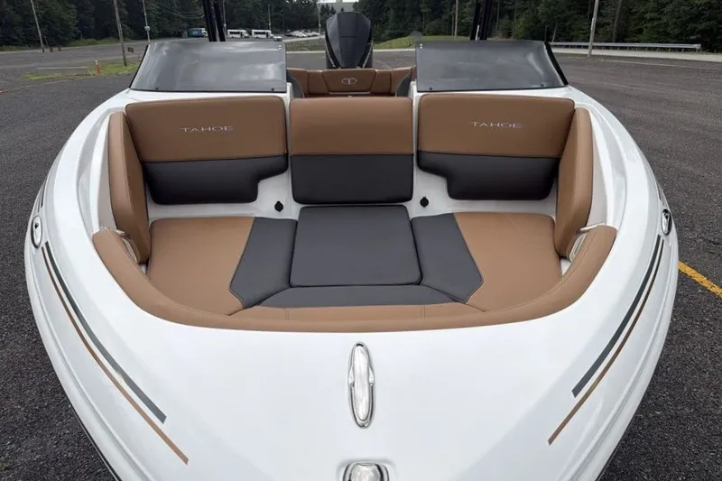 Slide: The Image of 2026 Tahoe 210 S boat interior with tan and gray seating, parked outdoors. - 7