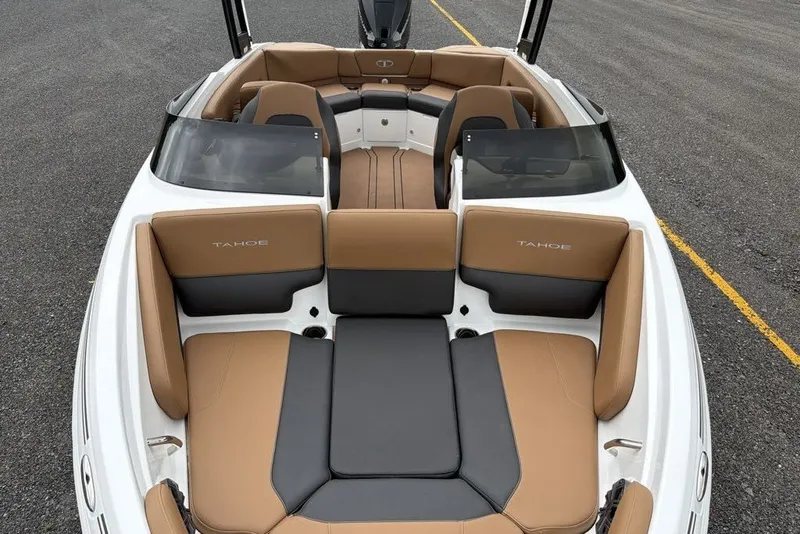 Slide: The Image of 2026 Tahoe 210 S boat interior with tan and black seating on a paved surface. - 8