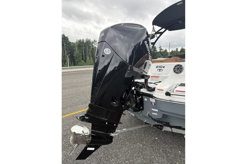 Slide: The Image of 2026 Tahoe 210 S boat with powerful Mercury outboard motor, parked on asphalt. - 12