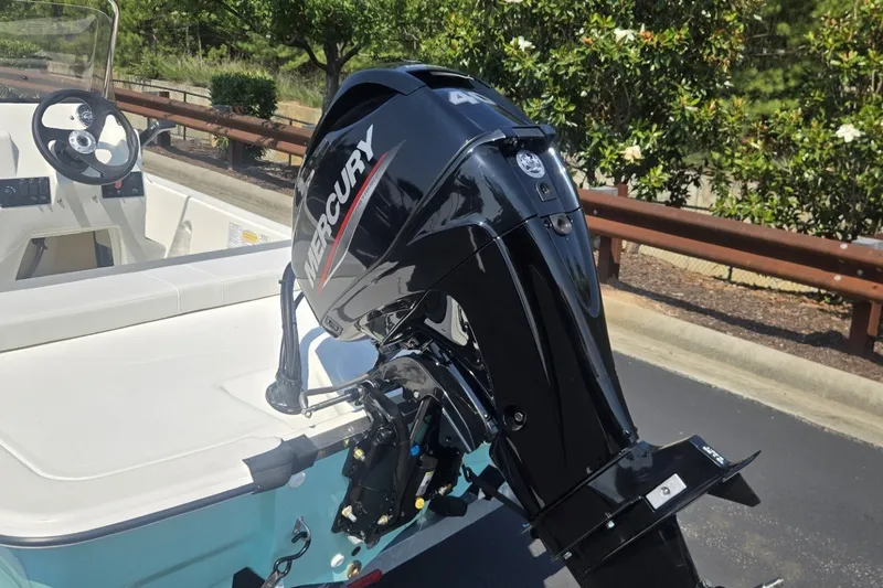 Slide: The Image of 2026 Mako Pro Skiff 13 CC with Mercury outboard motor, parked on a sunny day. - 4