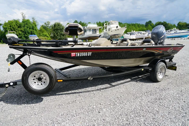 The Image of 2009 G3 Eagle 170 boat on trailer, parked on gravel with other boats in background. - 0