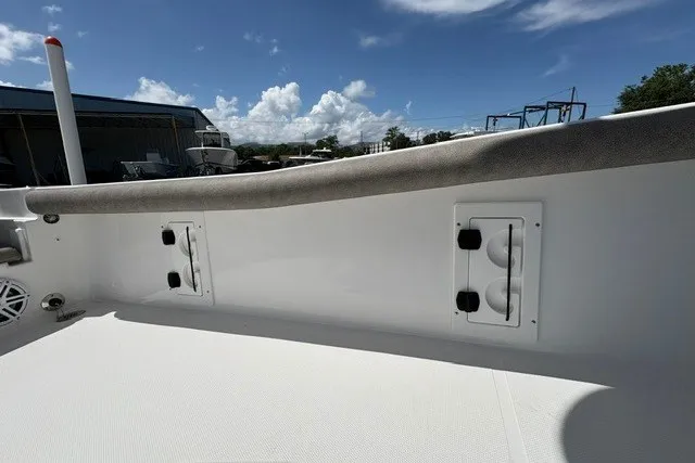 Slide: The Image of 2026 Sea Hunt BX25FS boat interior with rod holders under a clear blue sky. - 9