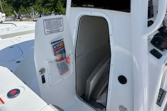 Slide: The Image of 2026 Sea Hunt BX25FS boat storage compartment with safety instructions and gear. - 13
