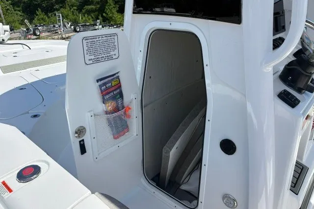 Slide: The Image of 2026 Sea Hunt BX25FS boat storage compartment with open door and visible interior. - 12