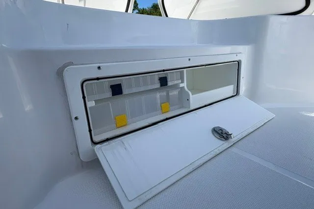 Slide: The Image of 2026 Sea Hunt BX25FS boat storage compartment with open hatch and secure latch. - 15