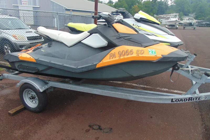The Image of 2015 Sea-Doo Spark 2up jet ski on Load Rite trailer in parking lot. - 2