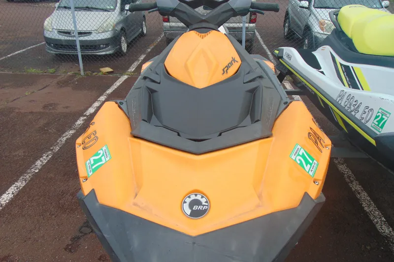 Slide: The Image of 2015 Sea-Doo Spark 2up jet ski in parking lot, orange and black design. - 4
