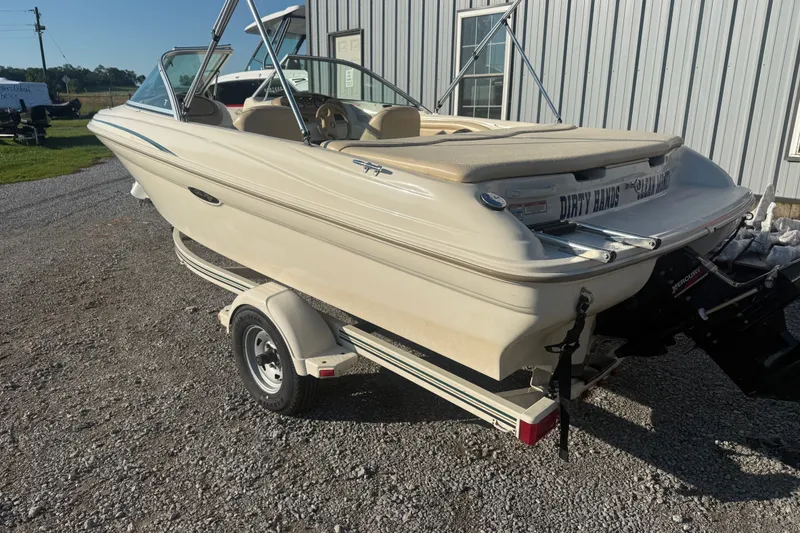 Slide: The Image of 2000 Searay 180 boat on trailer, parked outdoors near a building. - 4