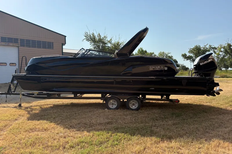 Slide: The Image of 2019 SunCatcher Amara boat on trailer, featuring sleek black design and Suzuki outboard motor. - 30