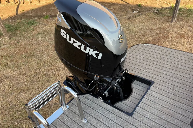Slide: The Image of Outboard motor on 2019 SunCatcher Amara boat, featuring Suzuki branding and deck ladder. - 19