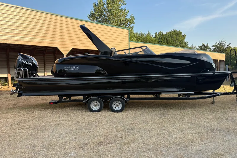 Slide: The Image of 2019 SunCatcher Amara boat on trailer, black exterior, Suzuki engine, parked outdoors. - 3