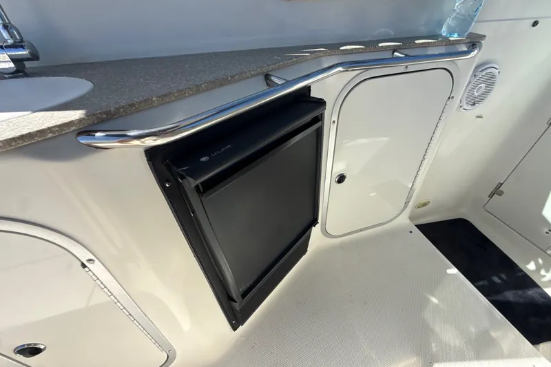 Slide: The Image of 1999 Maxum 3300 SCR boat interior with compact fridge and storage cabinet. - 16
