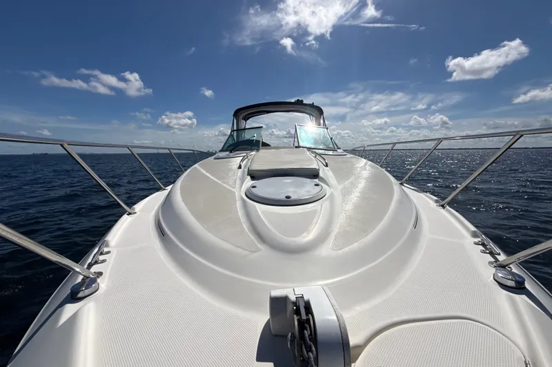 Slide: The Image of 1999 Maxum 3300 SCR yacht cruising on open water under a clear blue sky. - 61