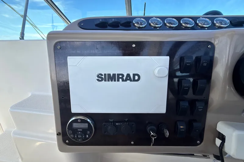 Slide: The Image of 1999 Maxum 3300 SCR boat dashboard with Simrad navigation system and control panel. - 22