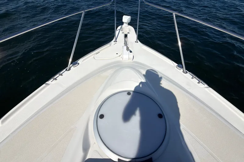Slide: The Image of Bow of 1999 Maxum 3300 SCR boat with shadow, railing, and ocean view. - 58