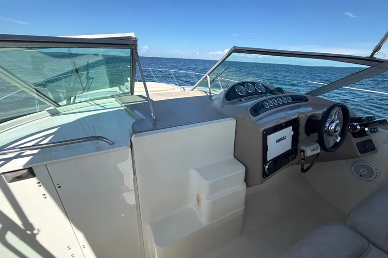 Slide: The Image of 1999 Maxum 3300 SCR boat cockpit with steering wheel and ocean view. - 53