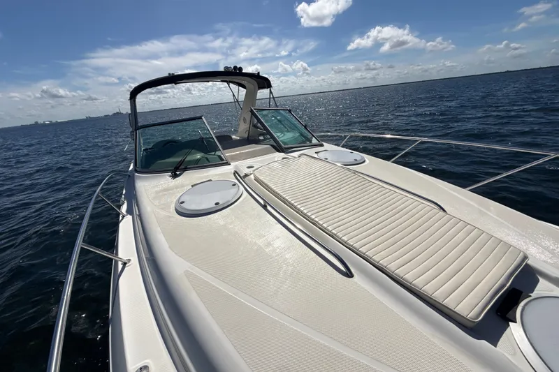 Slide: The Image of 1999 Maxum 3300 SCR yacht on open water under a clear blue sky. - 62