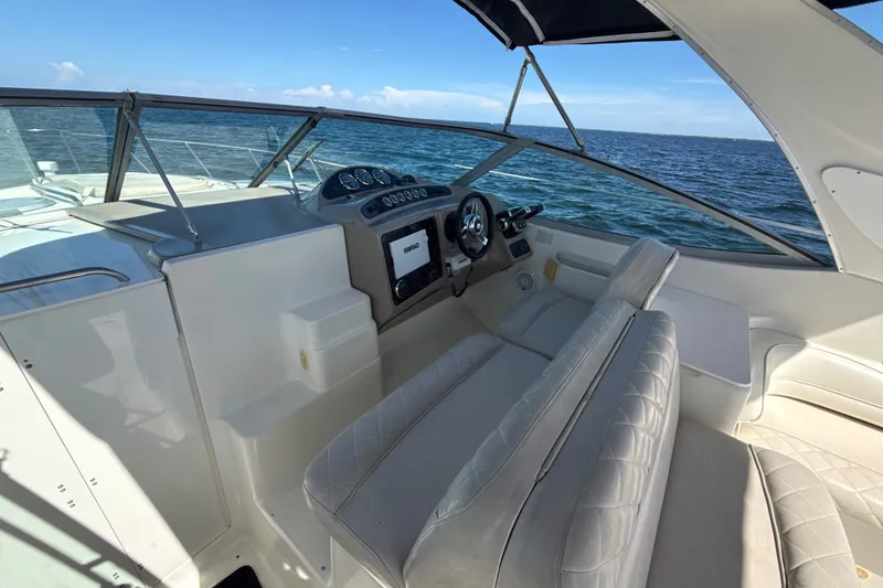 Slide: The Image of 1999 Maxum 3300 SCR boat cockpit with steering wheel, dashboard, and ocean view. - 18