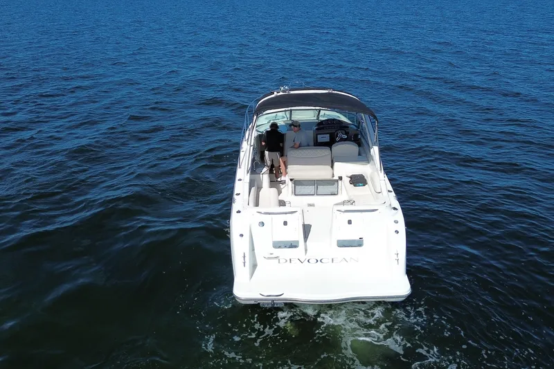 Slide: The Image of 1999 Maxum 3300 SCR boat cruising on open water, rear view. - 4