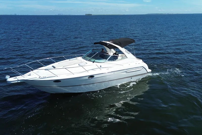 Slide: The Image of 1999 Maxum 3300 SCR cruising on open water under clear skies. - 67