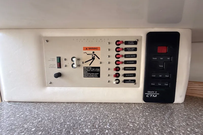 Slide: The Image of Electrical control panel on a 1999 Maxum 3300 SCR boat, featuring switches and warning labels. - 33