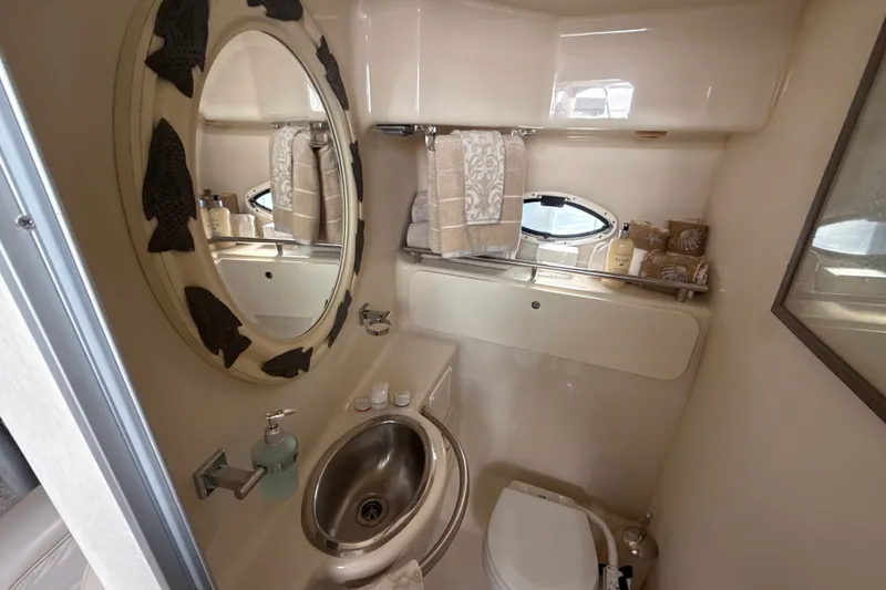 Slide: The Image of 1999 Maxum 3300 SCR yacht bathroom with oval mirror, sink, and toiletries. - 48