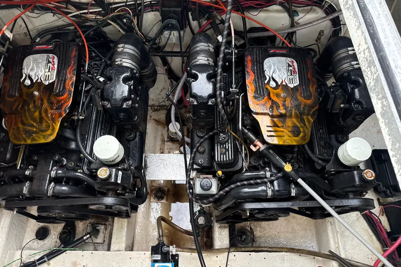 Slide: The Image of Twin engines in a 1999 Maxum 3300 SCR boat, featuring vibrant flame designs. - 64