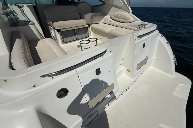 Slide: The Image of 1999 Maxum 3300 SCR boat interior with white seating and cup holders on open water. - 7