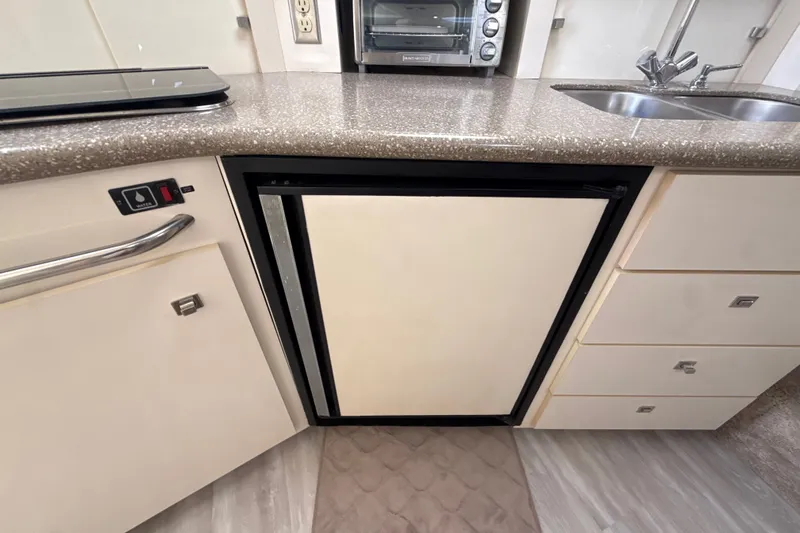 Slide: The Image of 1999 Maxum 3300 SCR yacht kitchen with compact fridge, sink, and countertop appliances. - 36