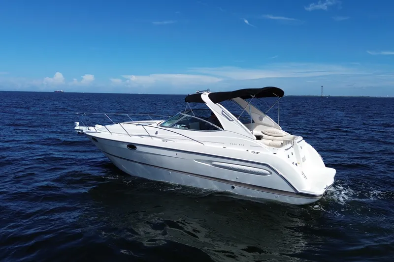 Slide: The Image of 1999 Maxum 3300 SCR boat cruising on open water under clear blue skies. - 5