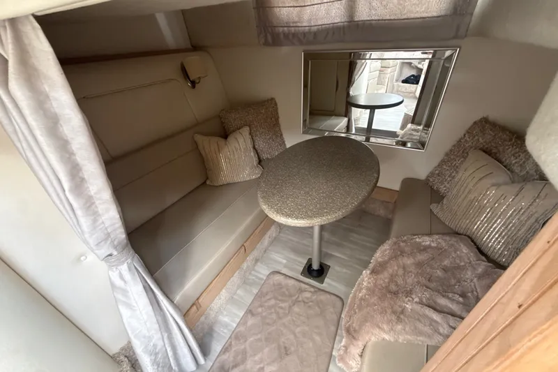 Slide: The Image of Cozy interior of 1999 Maxum 3300 SCR boat with seating and table. - 51
