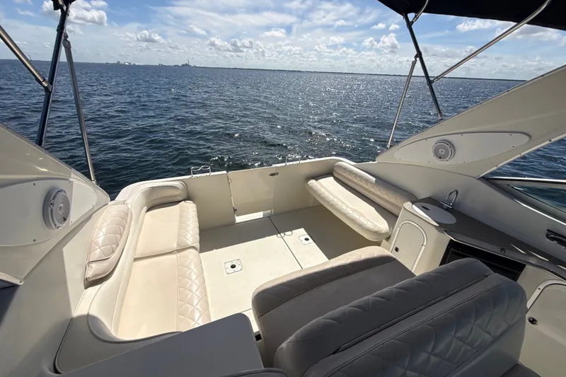 Slide: The Image of 1999 Maxum 3300 SCR boat interior with cushioned seating, overlooking calm ocean waters. - 63