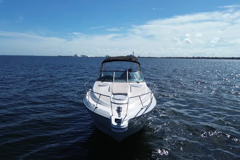 Slide: The Image of 1999 Maxum 3300 SCR boat cruising on open water under a clear blue sky. - 1